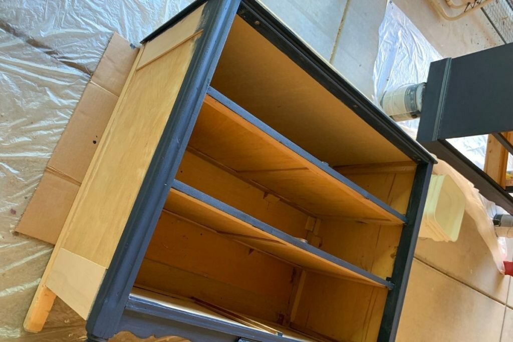An image of a vintage dresser being painted blue